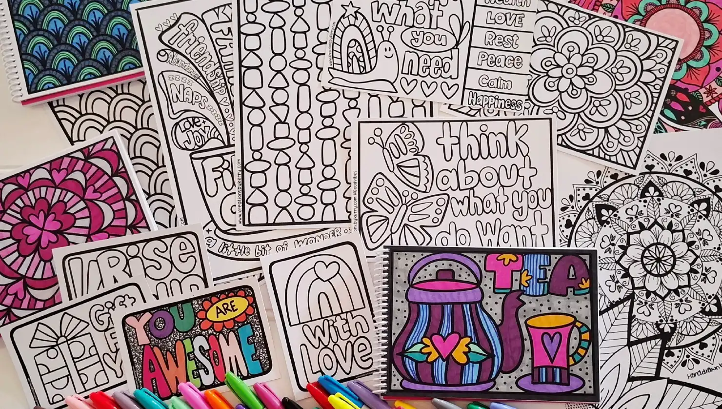 Collection of colouring pages featuring mandalas, hearts, flowers, positive messages, patterns, and doodle designs, displayed with colourful markers. 
